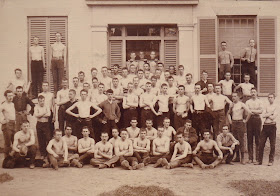 A photograph of a group of shirtless men.