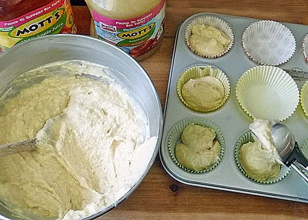 Applesauce Cupcakes batter being scooped into muffin tin and ready to bake