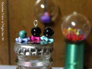 DIY octopus beads; cute little craft using beads and glue. Bottle cap shown for size.