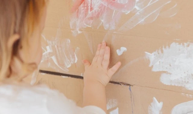 إصبع طفل يرسم صندوق من الورق المقوى