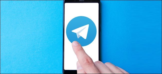 النقر بإصبع على أيقونة تطبيق Telegram الكبيرة على الهاتف الذكي.