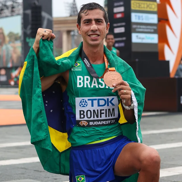 Caio com a medalha de bronze do Mundial e com a bandeira do Brasil nas costas