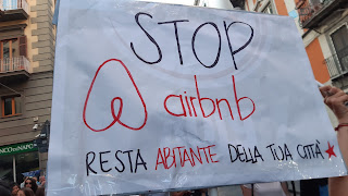 cartello che recita: stop airbnb resta abitante della tua città