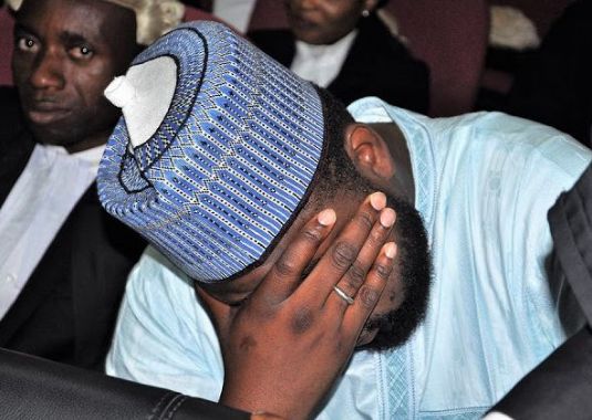 Shamsudeen Bala Mohammed hiding his face in court after being charged by the efcc