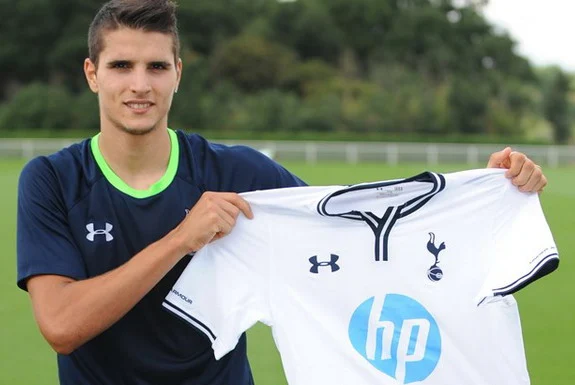 New Tottenham signing Erik Lamela poses with his new jersey at the club's training ground