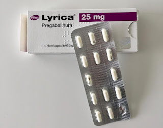 pack of lyrica with a blister of capsules lying on it