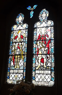 A double stained glass window showing St Michael and St George