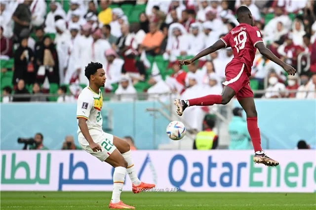 وكالة البيارق الإعلامية ودع المنتخب القطري بطولة كأس العالم 2022 ، وذلك بعد خسارته أمام السنغال 1/3 في المباراة التي أقيمت بينهما مساء اليوم باستاد الثمامة في إطار مباريات الجولة الثانية من المجموعة الأولى من المونديال. أحرز أهداف السنغال كل من بولاي ديا و فمارا دييدهيو وبامبا دينج في الدقائق 40 و 48 و 84 ، بينما أحرز محمد مونتاري هدف قطر الوحيد في الدقيقة 78. جاءت المباراة جيدة المستوى مفتوحة من كلا الفريقين اللذين تبادلا السيطرة على مجريات الأمور ، وإن كان المنتخب القطري كان الأكثر سيطرة لكن دون تحقيق الهدف المرجو ، في الوقت الذي لعب فيه الفريق السنغالي بذكاء وحقق هدفه من اللقاء. وبهذه النتيجة ، حصد المنتخب السنغالي أول 3 نقاط له بالبطولة ، فيما بقي رصيد قطر خاليا من النقاط ليكون أول المودعين للمونديال. الشوط الأول بداية المباراة جاءت حماسية من جانب المنتخب القطري الذي سيطر على مجريات الأمور في الدقائق الأولى وحاول تنظيم أكثر من هجمة على المرمى السنغالي ولكن دون خطورة تذكر . وواصل المنتخب القطري الضغط على أمل إدراك هدف يحافظ به على حظوظه في التأهل للدور الثاني ، وكانت تسديدة أكرم عفيف أقرب فرص العنابي على مرمى السنغال وإن خرجت أعلى مرمى ميندي وذلك بعد مرور 15 دقيقة وبمرور الوقت بدأ المنتخب السنغالي مجاراة نظيره القطري في السيطرة على مجريات الأمور ولكن دون خطورة حقيقية باستثناء تسديدة "ادريسا جاي" التي خرجت على يمين مشعل برشم حارس قطر. المباراة أصبحت مفتوحة بين الفريقين اللذين حاول كل منهما الوصول لمرمى الآخر بهجمة هنا وأخرى هناك ومحاولات متواصلة من كلاهما. خطأ وهدف و للمباراة الثانية على التوالي دفع المنتخب القطري ثمن الأخطاء القاتلة والساذجة لمدافعيه ، وذلك عبر خوخي بوعلام الذي أخطأ في التعامل مع كرة عرضية من الناحية اليسرى ، حتى تهيأت الكرة أمام بولاي ديا مهاجم السنغال الذي لم يتوانى عن تسديد الكرة بسهولة وقوة لتسكن مرمى مشعل برشم في الدقيقة 40. وسادت حالة من الارتباك في صفوف المنتخب القطري بعد هدف السنغال ، وهي الحالة التي كاد أن يستغلها منافسه ، قبل أن يرتب العنابي صفوفه من جديد وينظم أكثر من هجمة على مرمى ميندي لكن دون خطورة حقيقية. الشوط الثاني وعلى الرغم من البداية الحماسية للمنتخب القطري في الشوط الثاني ، إلا أن الفريق السنغالي فاجأ أصحاب الأرض بهدف مبكر ثان ، عندما استثمر "فمارا دييدهيو" العرضية التي وصلت له من الركلة الركنية وأودعها برأسه على يمين مشعل برشم محرزا الهدف الثاني في الدقيقة 48. وكشر العنابي عن أنيابه بعد الهدف الثاني ، وسيطر على مجريات الأمور وأهدر أكثر من فرصة خطيرة على المرمى السنغالي ، منها تسديدة قوية لعبد الكريم حسن خرجت على يمين ميندي ، وأخرى للمعز علي سددها من داخل المنطقة وتصدى لها الحارس السنغالي  هدف أول وسيطر المنتخب القطري تماما على مجريات الأمور وازدادت هجماته خطورة من دقيقة لأخرى ، حتى أسفرت تلك السيطرة عن هدف مستحق ، وذلك عندما انطلق اسماعيل محمد من الجهة اليمنى ولعب عرضية متقنة قابلها محمد مونتاري برأسه في مرمى ميندي مسجلا أول أهداف قطر في كأس العالم في الدقيقة 78. هدف ثالث ووسط حالة من الاستنفار للمنتخب القطري بغية إدراك التعادل ، فاجأ المنتخب السنغالي أصحاب الأرض بهدف ثالث قضى به على كل أمال القطريين في العودة للمباراة ، وذلك عبر بامبا دينج في الدقيقة 84.