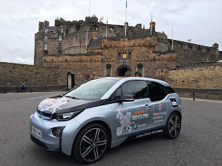 BMW i3 electric car with range extender petrol engine parked in front of Edinburgh castle