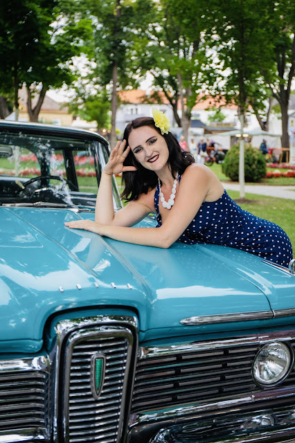 Kerstin vom utsc dancefire in einem kleid von boutique new vintage auf einem türkisen oldtimer ford mustang lehnend bei rocknroll im kurpark Bad Sauerbrunn