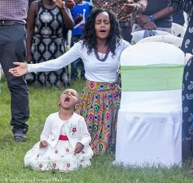 Trending photos of 3-year-old girl on her knees and in tears as she prays and worships God during a church service