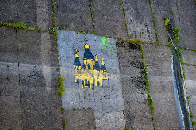 Рисунок желтого собора на бетонной набережной