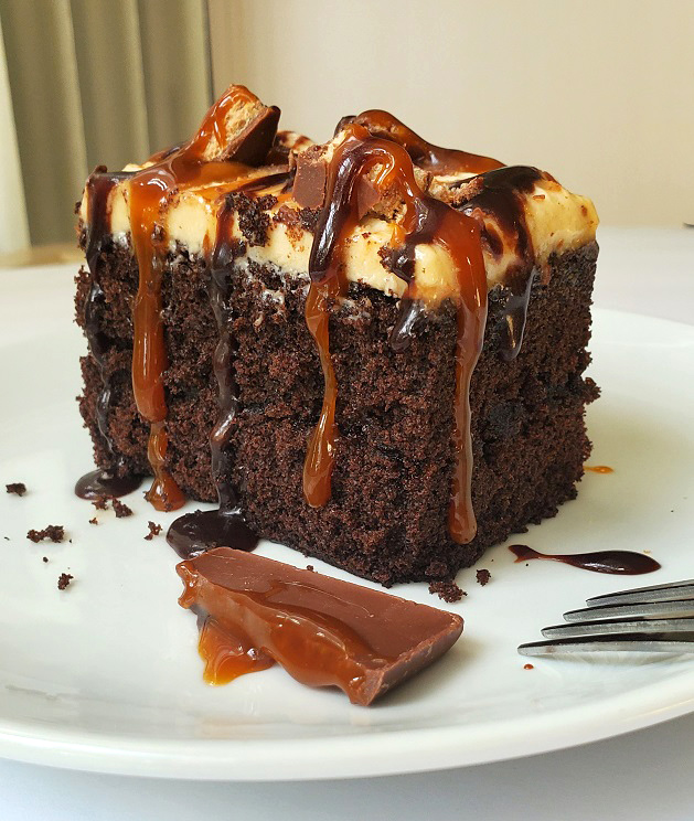 chocoalte caramel poke cake on a plate with chocolate filled caramel