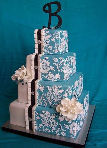 Blue damask wedding cake over thress square tiers with orange roses
