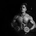 Grayscale photo of a man holding pair of dumbbells