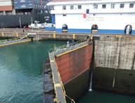 Canal do Panamá, Gatun Locks - Esta é a comporta no lado Caribenho. Conseguem ver a diferença no nível da água. Através do princípio dos vasos comunicantes ambas as câmaras ficam ao mesmo nível, as portas abrem-se e o navio avança para a câmara seguinte. Conseguem ver lá ao fundo à esquerda um grande navio de contentores a atravessar o canal na direção oposta.