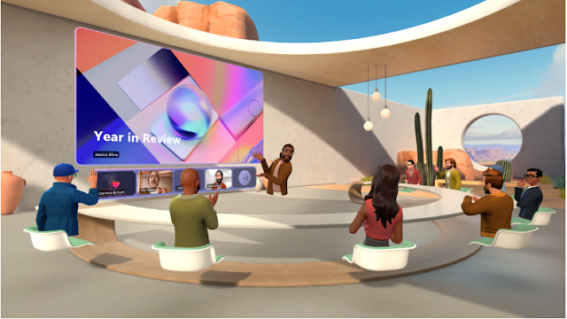 Image of an Immersive Space within Microsoft Teams, showcasing a 3D virtual meeting environment designed for interactive presentations. Avatars representing meeting participants are seated in a semi-circle, facing a large, curved display screen that reads 'Year in Review'. The environment mimics a desert oasis with sand-colored structures, cacti, and expansive canyon views through the open window, promoting a relaxed and engaging virtual meeting atmosphere. This feature exemplifies Teams' innovative approach to enhancing remote collaboration.