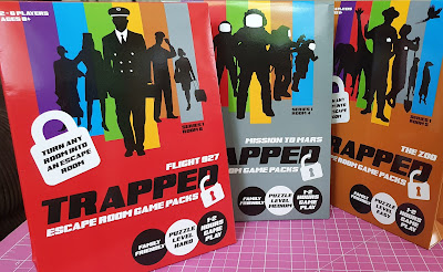 All 3 new Trapped escape room games in packaging laid out on table