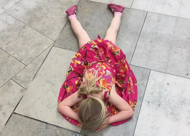 A young girl lying on the floor in a shopping centre having a tantrum