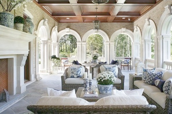 Magnificent loggia with stone fireplace blue and white decor and archways by Enchanted Home