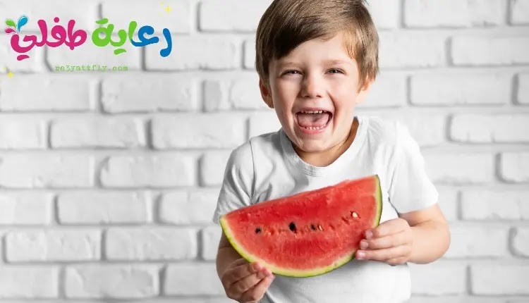 صورة طفل ممسك بشريحة من البطيخ، وهو مبتسم معبراً عن فوائد الفواكه للأطفال.