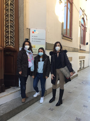 María en la puerta de su empresa con la coordinadora y una profesora