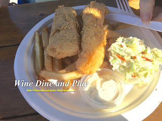 Two slim golden fried tenders with fries and coleslaw make up the Paradise Grille fish and chips dish on St Pete Beach