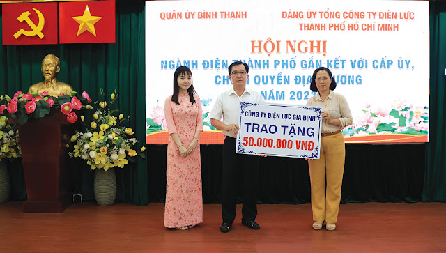 Đồng chí Trần Xuân Lâm trao bảng tượng trưng 50 triệu đồng  hỗ trợ quận thực hiện công tác an sinh xã hội. (Ảnh: MD)