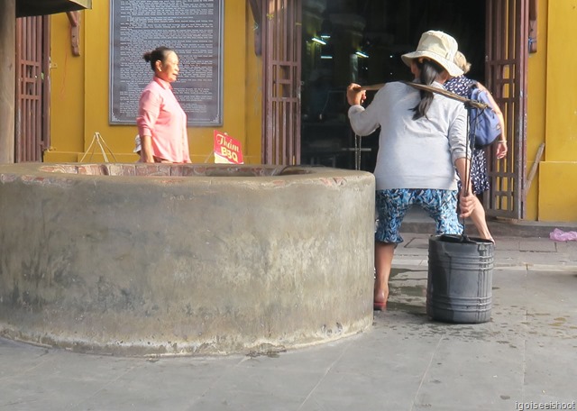 Drawing water from a well outside the Hoi An Central Market
