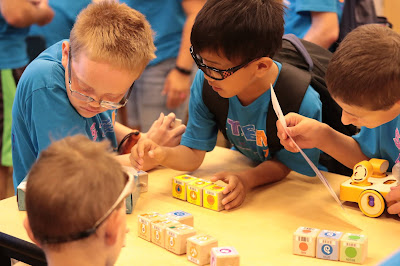   Elementary age male students writing a program using the Kibo program blocks. 