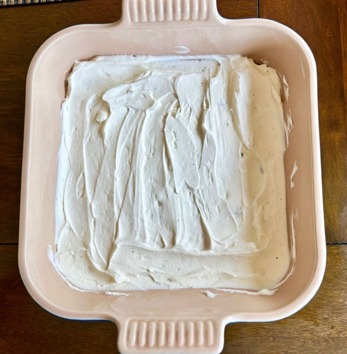 Whipped cream layer spread in the bottom of the pan.