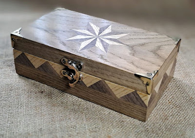 a photograph of a small wooden box that has been decorated using Marquetry