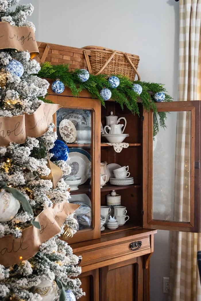 blue and white ornaments, flocked tree, paper ribbon, pine hutch