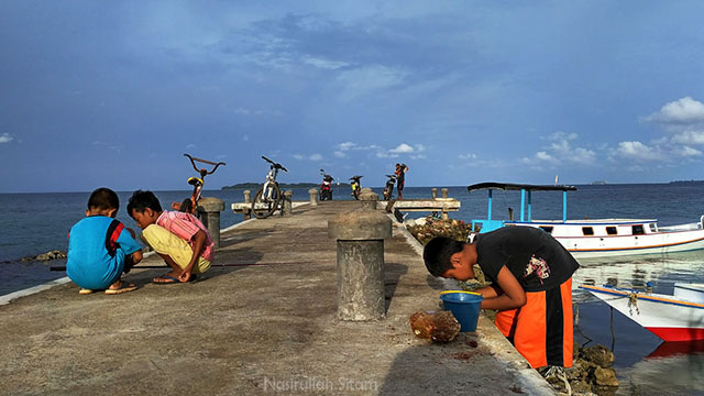 Anak-anak Karimunjawa sedang asyik memancing ikan di pelabuhan