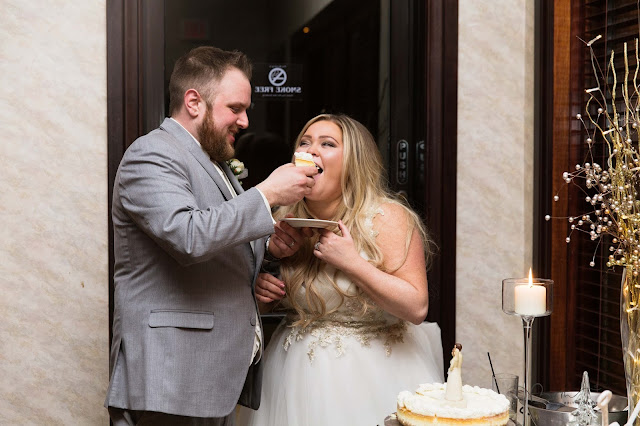 bride and groom feeding each  other cake at italian american cultural center in Clinton Township