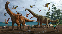 A group of dinosaurs, including a diplodocus, stands near a pond.