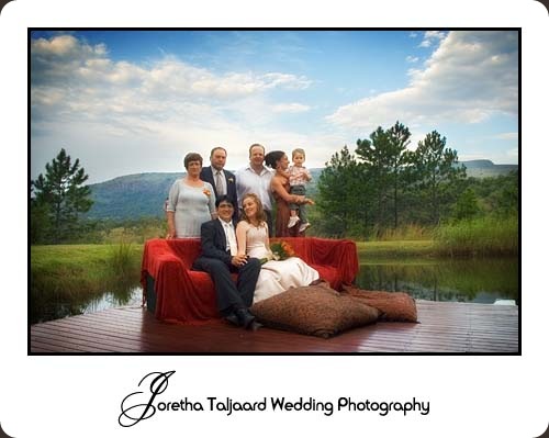 Wedding party group shot in front of lake