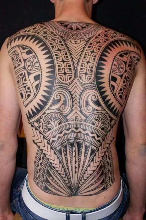 Hombre con tatuaje maori en la espalda completa