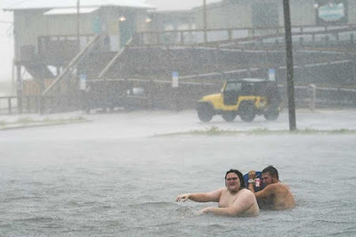 People play in a flooded parking lot at Navarre Beach, Tuesday, Sept. 15, 2020, in Pensacola Beach, Florida- AP photo