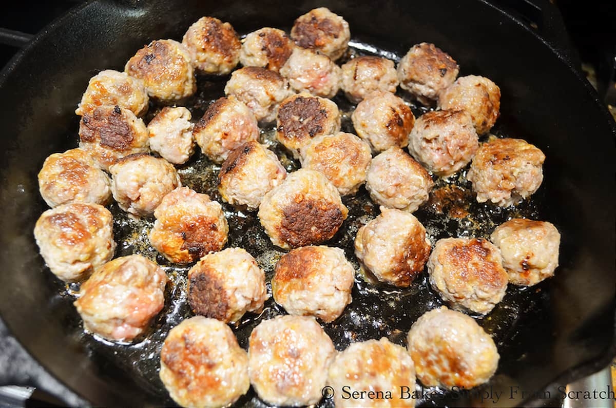 Brown Meatballs in a cast iron pan for Sweet and Sour Meatballs.