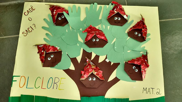 Painel Folclore com dobraduras de Sacizinhos e árvore de recorte de contorno de mãos.