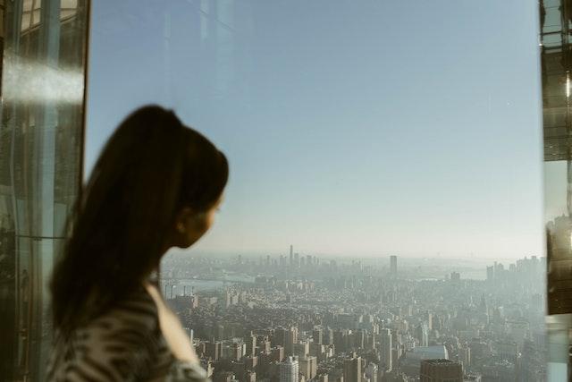 una mujer mirando la ciudad de Nueva York desde un edificio alto