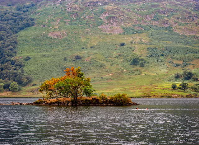 A closer view of the island with two swimmers in the water