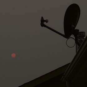 red sun through gray clouds with direct tv dish in foreground