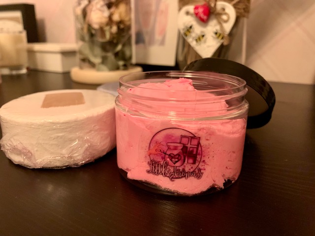 Tub of shower fluff, with bath bombs in the background