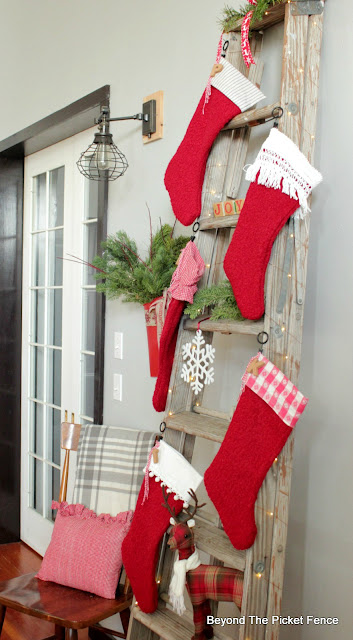 wrap fairy lights around an old ladder for a stocking hanger