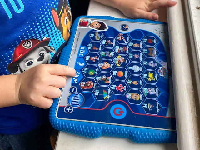 Close up of child playing on the PAW Patrol toy tablet to review it