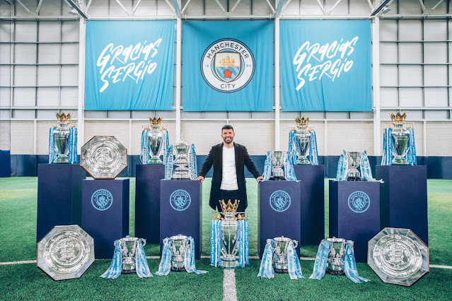 Sergio Aguero pose with Man City trophies
