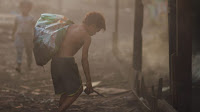 A child scavenges for coal scraps in smoggy Manila (Photo Credit: Flickr/Adam Cohn) Click to Enlarge.