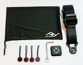 the box contains the strap, camera base plate, a hex key, 4 anchors and a small storage bag